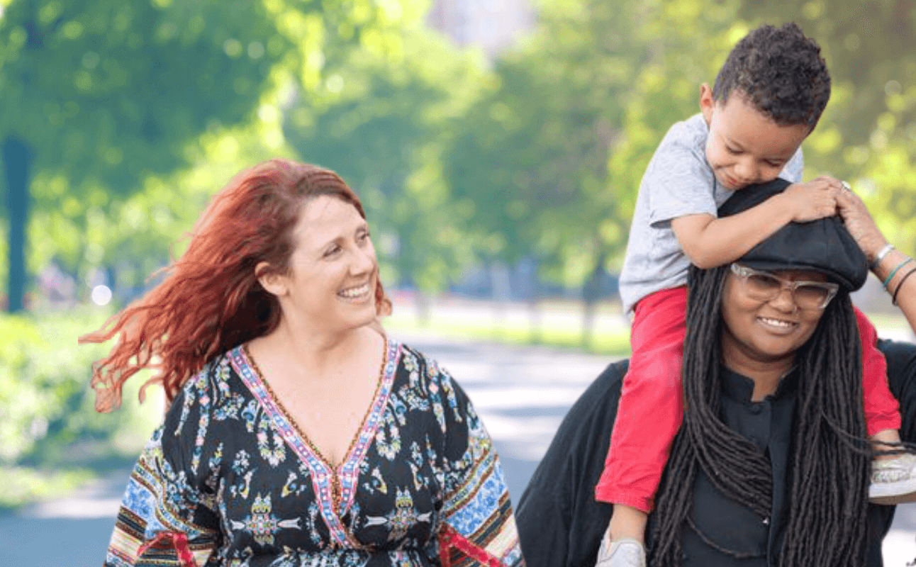 Adoptive parents with child on shoulder
