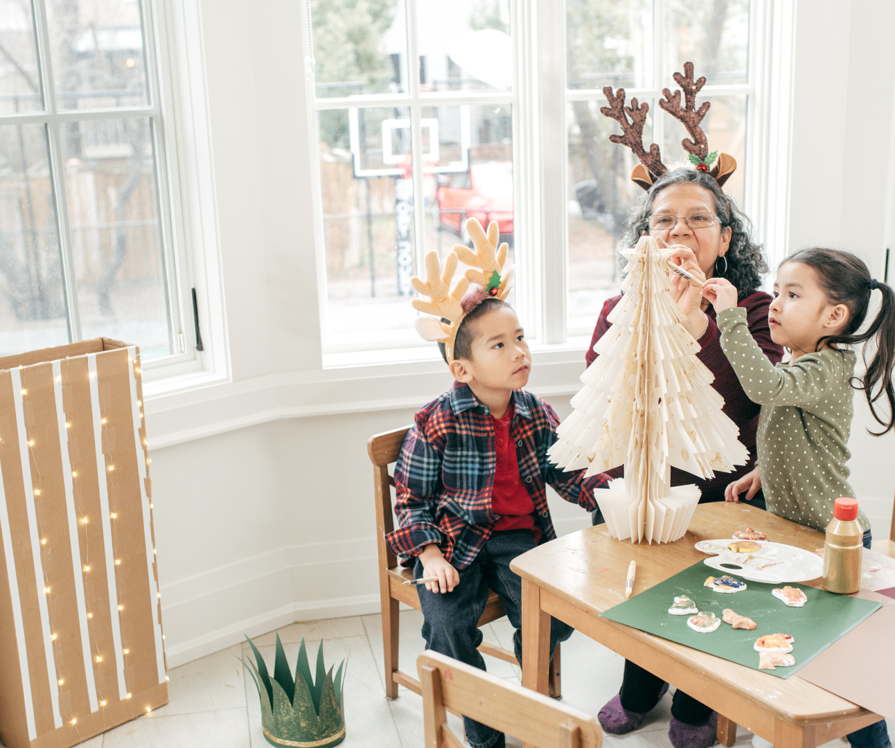 2 children waiting building a paper christmas tree