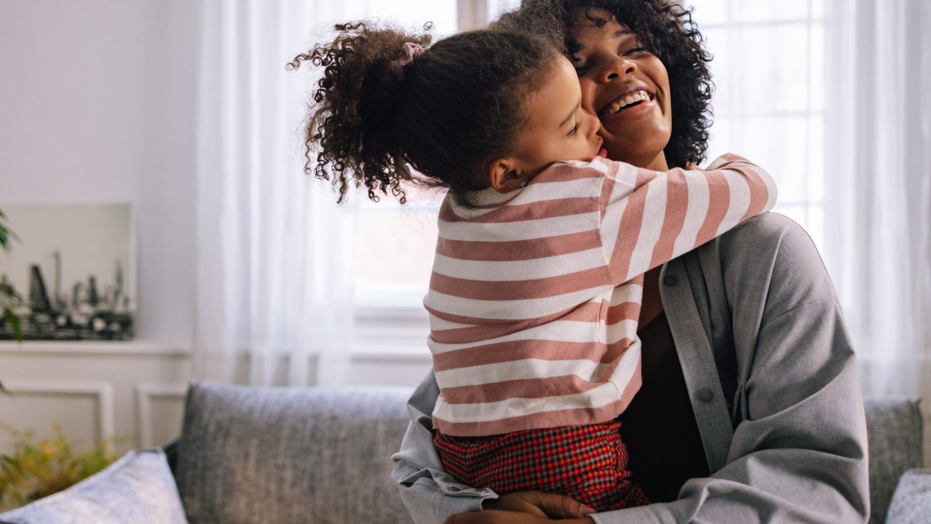 Dual heritage family of two, mother and her daughter, hugging each other with a lot of love.
